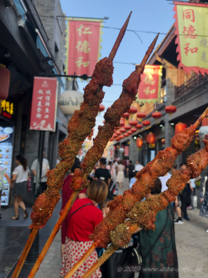 北京、前門前の歩行街で食べる猪肉串