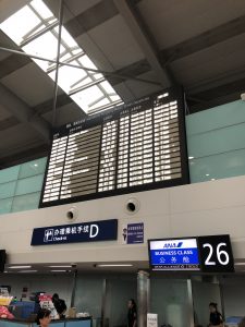 大連周水子空港の26番チェックインカウンター前の様子。上には飛行機の出発案内板がある。